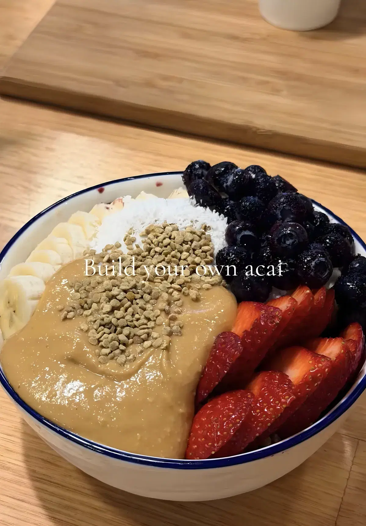 Build-your-own acai bowl with peanut butter, bee pollen, coconut, banana, blueberries and strawberries