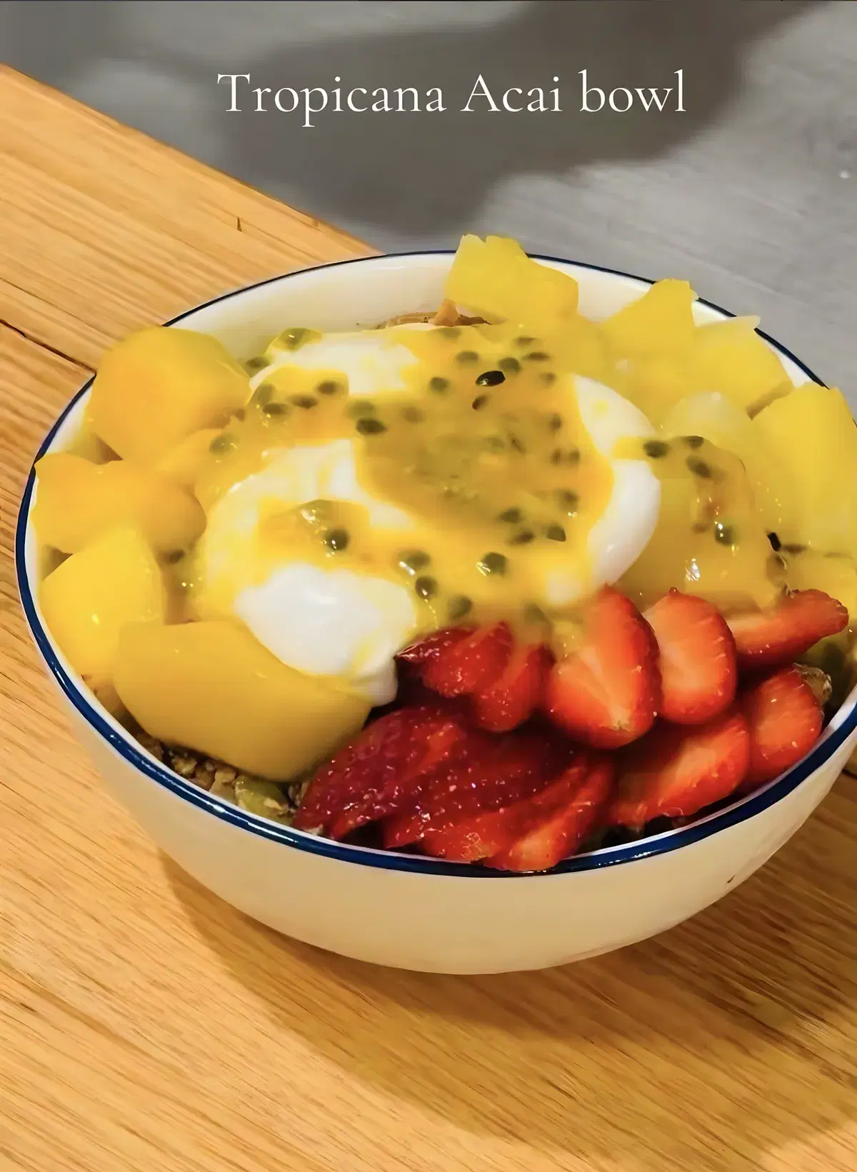 Tropicana acai bowl topped with mango, strawberries, a dollop of yoghurt and passionfruit